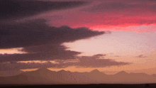 a sunset sky with mountains in the background