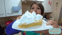 a woman is holding a slice of pie in front of a sign that says " silvana cocina suscribete "