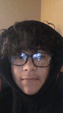 a young boy wearing glasses and a black hoodie