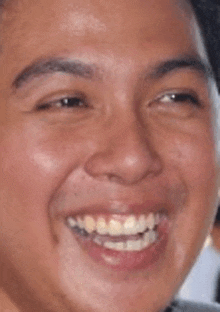 a close up of a man 's face smiling with his mouth open .