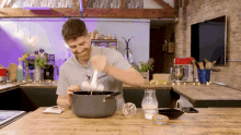 a man wearing a shirt that says started is cooking