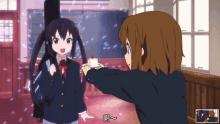 a girl in a school uniform is holding a piece of cake in front of another girl