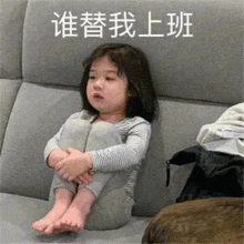 a little girl is sitting on a couch with her legs crossed and making a funny face .