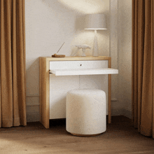 a white ottoman sits next to a wooden desk