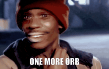 a man wearing a red beanie is smiling with the words one more orb above him