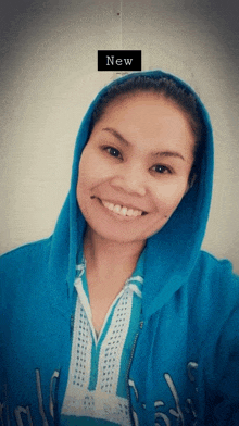 a woman wearing a blue hoodie with the word new on the bottom