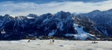 a ski lift is going up a snowy slope with mountains in the background