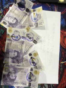 a bunch of 20 pound notes laying on top of a letter