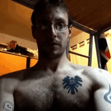 a shirtless man with a tattoo of an eagle on his chest has glasses