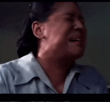 a woman in a blue shirt is crying in a video