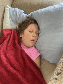 a little girl is sleeping on a couch with a pillow that says cooling