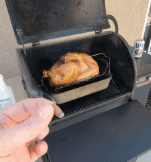 a can of lite beer sits on a table next to a grill with a turkey in it