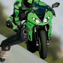 a person is riding a green ninja motorcycle