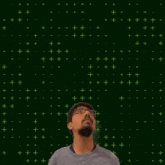 a man with glasses and a beard stands in front of a green background with the number 17 on it