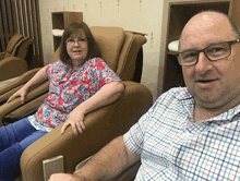 a man and a woman are sitting in chairs and smiling