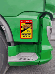 a green truck has a sticker that says attention baguette morts