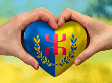 two hands make a heart shape with a blue and yellow heart