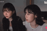 two girls are looking at something with the number 385,518 in the upper right corner