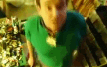a blurry picture of a man wearing a green shirt and a blue shirt