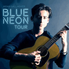 a young man is holding a guitar in his hands on the cover of a blue neon tour album .