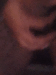 a close up of a person 's face with a dark background .