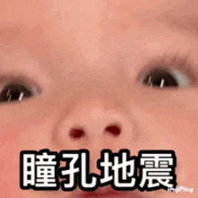 a close up of a baby 's face with chinese writing on it .