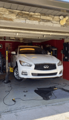 a white infiniti is parked in a garage