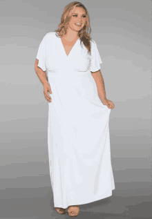 a plus size model wearing a white dress with a plunging neckline