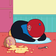 a penguin wearing a red hat with the letter p on it is laying on the floor