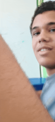 a close up of a man 's face with a white board behind him