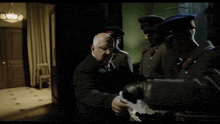a man in a suit talks to a man in a military uniform who says shoot her before him