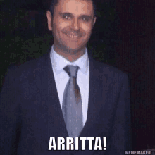 a man in a suit and tie is smiling with the words " arritta " below him