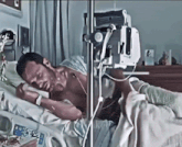 a man is laying in a hospital bed with a drip on his chest
