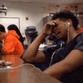 a man wearing headphones is crying in a classroom