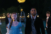 a woman in a blue dress is walking with a man