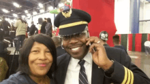 a man in a pilot 's hat talks on a cell phone next to a woman