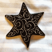 a black star with white swirls on it on a striped cloth