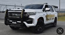 a white sheriff 's vehicle is parked on the street