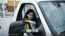 a woman is sitting in a white truck with the words " good to go " written on the side