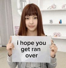 a girl holds up a sign that says i hope you get ran over