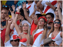 a group of people are standing in a stadium watching a game .