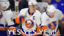 a group of hockey players are standing on the ice and one of them is wearing a jersey with the letter c on it .