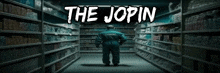 a man in a blue jumpsuit is walking through a grocery store aisle with the words the jopin above him