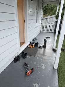 a bunch of shoes on a porch including a pair of nike shoes