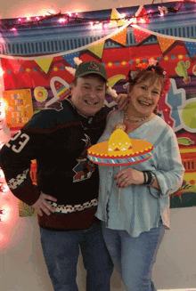 a man wearing a sweater with the number 23 on it poses with a woman