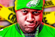 a man wearing a green hat and green shirt is making a face .