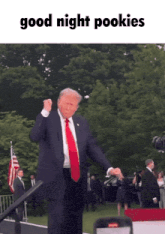 a man in a suit and tie is dancing in front of a sign that says good night pookies