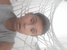 a young boy is laying in a hammock and looking at the camera with a surprised look on his face