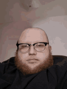 a bald man with glasses and a beard