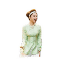 a woman in a green shirt and white skirt is laughing and making a funny face .